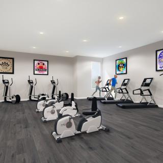 A modern gym with various exercise equipment including stationary bikes and treadmills.