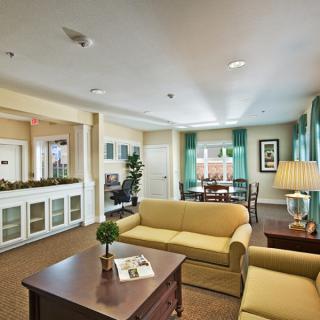 A cozy and well-furnished living room with sofas, a coffee table, lamps, and decorative elements.