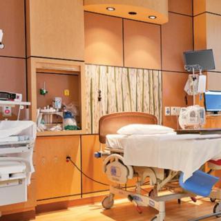 A modern hospital room equipped with medical devices and a patient bed.