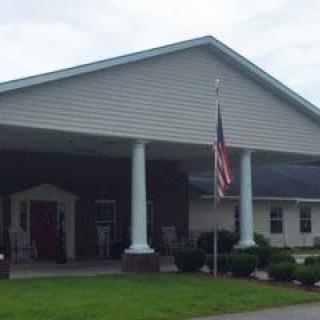 A building with a covered entrance featuring columns and an American flag.