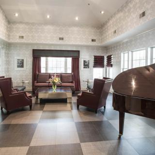 A stylish lounge area with a grand piano and elegant furniture.