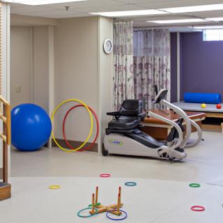 A rehabilitation gym featuring various exercise equipment and colorful accessories for therapy.