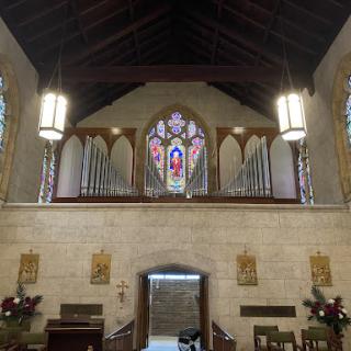 The serene interior of a church featuring beautiful stained glass windows and a wooden ceiling.