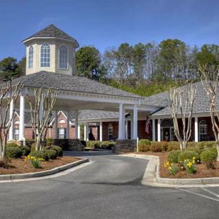 A well-maintained building with a circular driveway and landscaped surroundings.