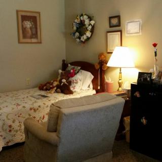 A cozy bedroom with a single bed, floral bedding, and decorative elements.