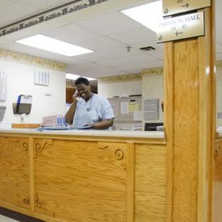 A nurse at the reception desk in a hospital setting.