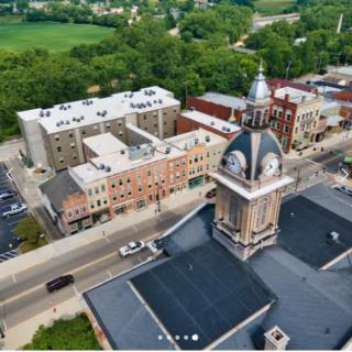 Aerial view of a town showcasing a prominent clock tower and surrounding buildings.