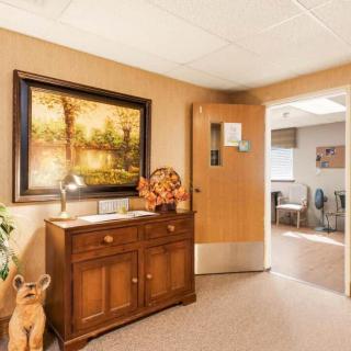 An inviting reception area featuring a wooden cabinet, a decorative painting, and warm lighting.