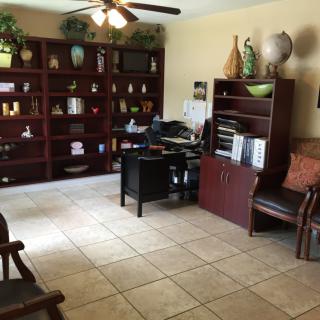 A tidy office space with a desk, bookshelf, and various decorations.