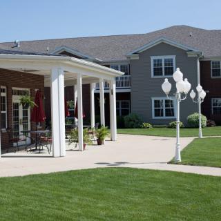 A modern residential building with a well-maintained lawn and patio area.