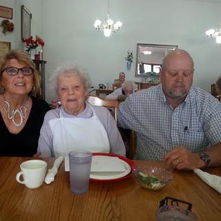 A group of three people sitting together at a dining table in a restaurant.