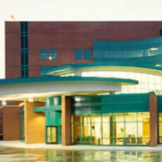 A modern architectural building with a glass facade and prominent entrance.