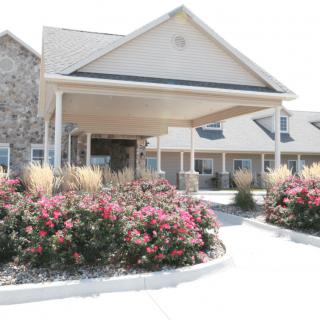 A well-landscaped building entrance with flowering plants.