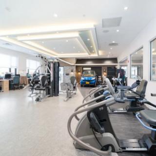 A modern gym with various exercise equipment including treadmills and weight machines.
