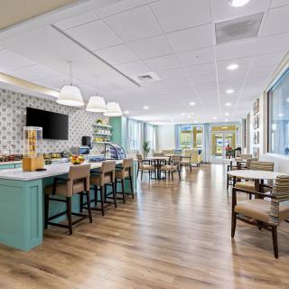 A modern and spacious dining area with wooden flooring, bar counter, and ample seating.