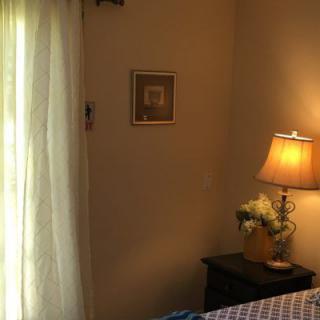 Cozy bedroom corner with warm lighting and soft curtains.
