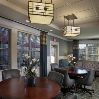 A modern meeting room with stylish lighting, round tables, and comfortable seating.
