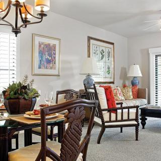A cozy living and dining area with elegant furniture, decorative artwork, and warm lighting.