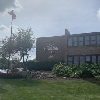 Exterior view of a school building with signage and a flag.