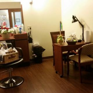 A small office space with a work desk, chairs, and a lamp.