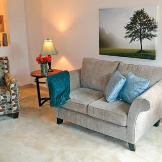 A cozy living room with a sofa, an armchair, and elegant decor.
