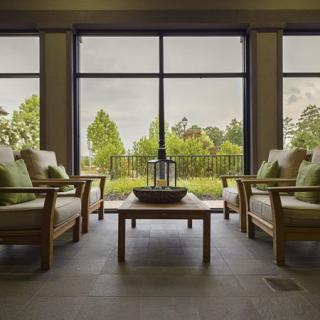 A modern living room with large windows offering a scenic nature view.
