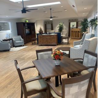 A spacious and well-decorated living room with comfortable seating and a wooden dining table.
