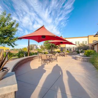 A beautifully designed outdoor space featuring a red canopy, perfect for relaxation under the clear blue sky.
