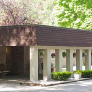 A small, modern building surrounded by trees and natural light.