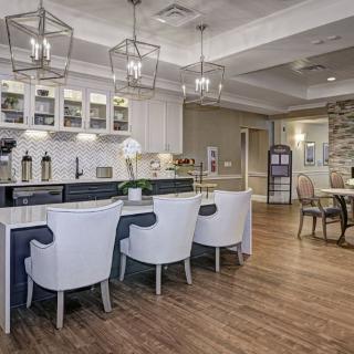 A modern kitchen interior with a central counter and stylish lighting.