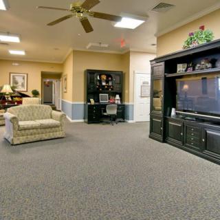 A spacious living room with a sofa, television, and bookshelf.
