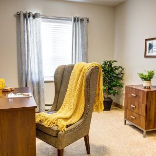 A cozy office space with a desk, chair, and decorative elements.