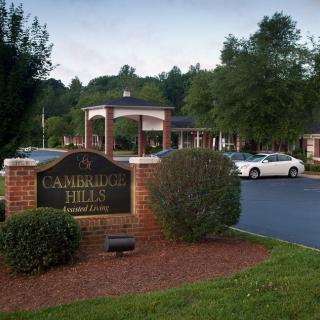 Entrance to an apartment complex with a landscaped entrance and parked cars.