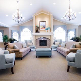A spacious and bright living room with comfortable seating and elegant chandeliers.