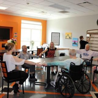 Seniors participating in a group exercise activity at a community center, promoting wellness and rehabilitation.