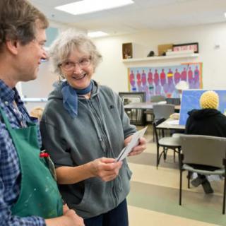 Two people engaging in conversation inside a community center.
