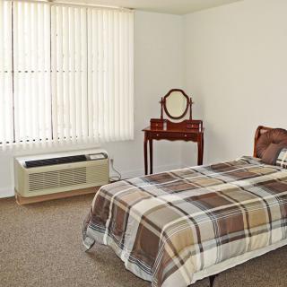A simple bedroom with a single bed and a vintage dresser.