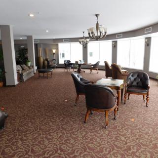 A spacious lounge area with elegant furniture and a chandelier.