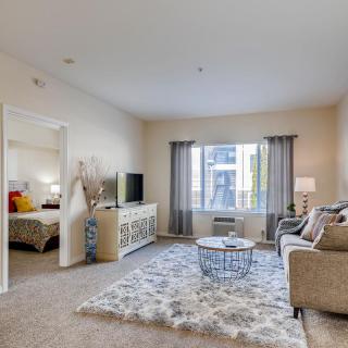 Modern apartment living room with stylish decor and a view into the bedroom.