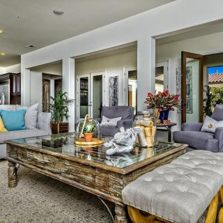 A stylish living room with comfortable seating, elegant decor, and a glass-topped coffee table.