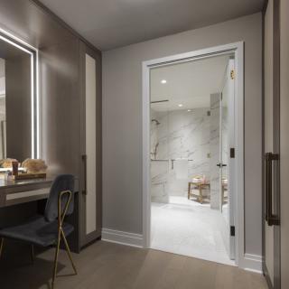 A modern and luxurious bathroom with a marble-tiled shower and elegant vanity area.
