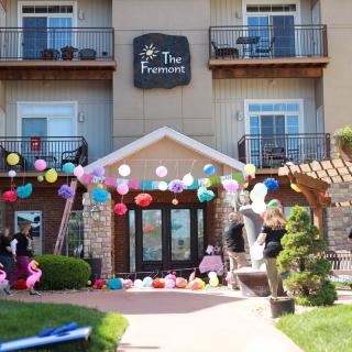 The entrance of a building decorated with colorful balloons for a celebration.