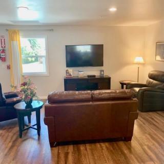 A cozy living room with comfortable seating, a television, and warm lighting.