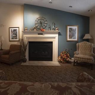 A cozy living room with a nautical-themed decor, featuring a fireplace flanked by armchairs.