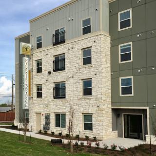A contemporary multistory building featuring a mix of stone and modern materials.