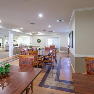 A well-lit dining area with neatly arranged tables and chairs.