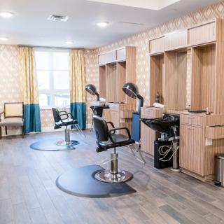 A modern beauty salon with styling stations and mannequin heads for hairdressing practice.
