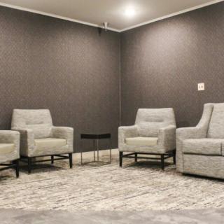A minimalist living room with modern chairs and a patterned carpet.