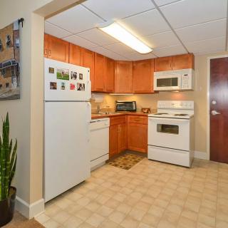 A cozy kitchen with wooden cabinets and standard appliances, including a refrigerator, oven, and microwave.
