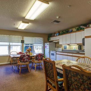 A cozy kitchen and dining area with wooden furniture and bright lighting.